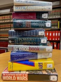 Stack of ten library books on a table